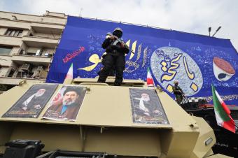 عنصر أمن متأهّب خلال تشييع قادة قتلوا خلال الحرب في طهران أمس (أ ف ب)